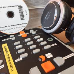 DAISY player, DAISY CD and headphones grouped together on a desk