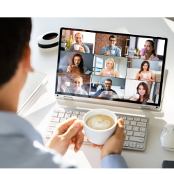 A person holding a coffee cup while tuned into a virtual meeting on their computer with several other people.