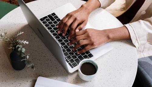 Hands typing on a laptop.