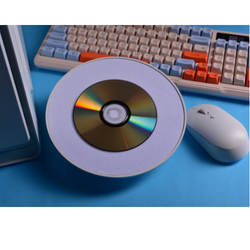 CD burner sits beside a keyboard and mouse.