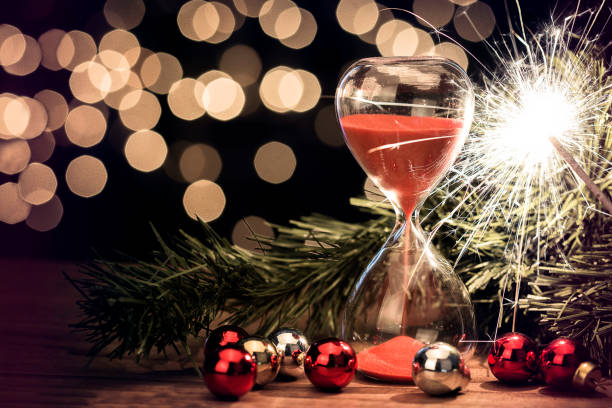 a sparkler next to an hourglass with red sand passing through