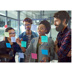 A group of people stand in front of a wall with sticky notes