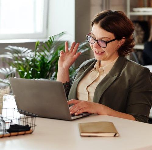 Woman wearing glasses giving presentation in front of a laptop