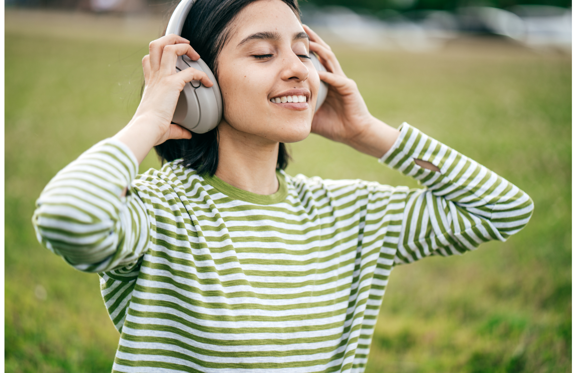 Young woman smiles while listening to her headphones.