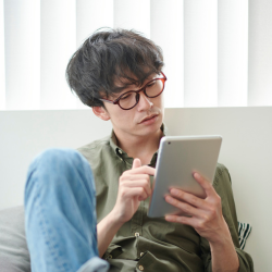 A young man reads on a tablet