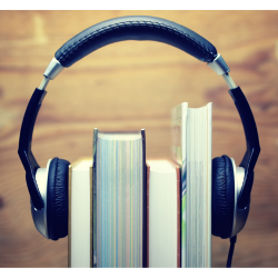 Headphones are attached to 4 hardcover books as if they were listening to the books. 