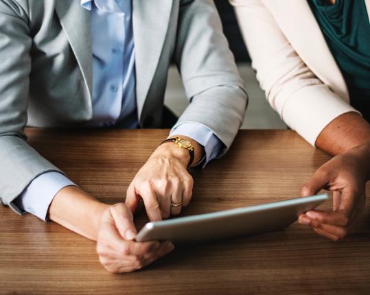 Two people looking at a tablet