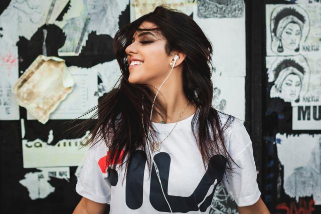 Young woman listening to audiobook smiling