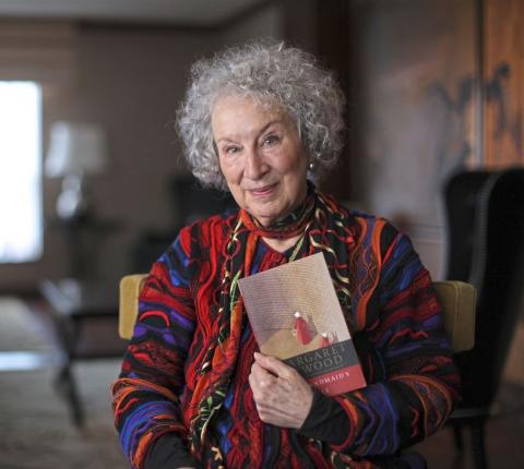 Photo of Margaret Atwood holding a copy of The handmaid's tale