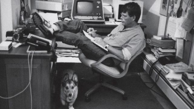 Photograph of Stephen King in his office reading