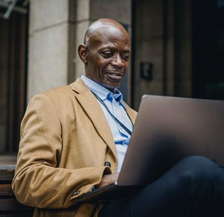 elderly black man in a suit using a computer