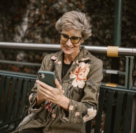 an elderly man woman downloading a book on an iphone