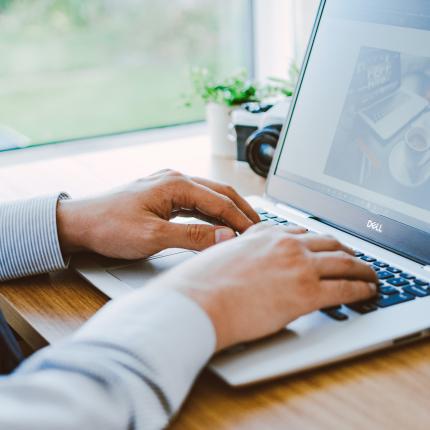 A photo of hands using a Dell laptop